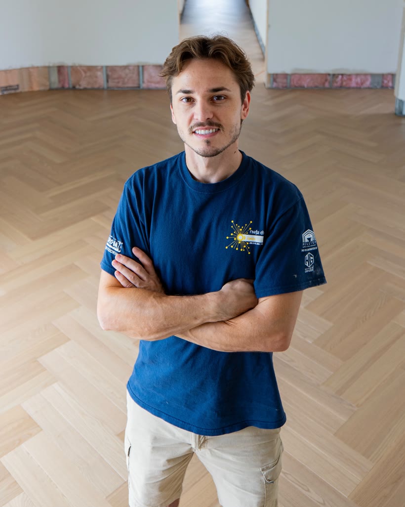 Cristian Mocanu, founder of Custom Flooring Projects, standing on a finished European-oak herringbone floor